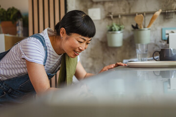 Japanese woman organize kitchen utensils and cutlery in kitchen drawer
