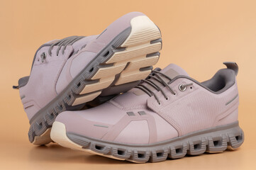 Stylish gray athletic shoes displayed on soft beige background portrait