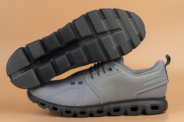 Modern gray athletic shoes with unique sole design on neutral background