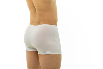 athletic guy in white tight boxer shorts standing with his back on isolated background. men's health: hemorrhoids, prostatitis. strong male ass after gym.