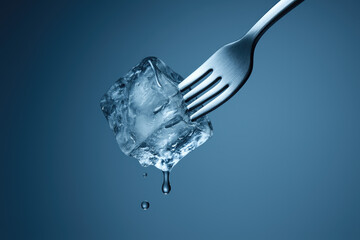 Fork Piercing Ice Cube in Mid-Air – Frozen Droplets and Icy Motion Concept
