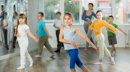 Girls with boys repeat teaches sequences of movements during training, train to perform hip hop,...