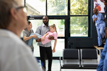 Girl fainted and her african american father is carrying her in the hospital, waiting for immediate...