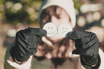 Mental Illness Awareness Day. Woman holding faces with emotions.
