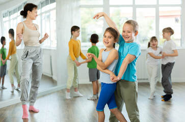Fototapeta premium Girl paired up with boy and training to perform slow couple dance, rehearse performance. Devotion of modern trend pastime, active lifestyle and hobbies