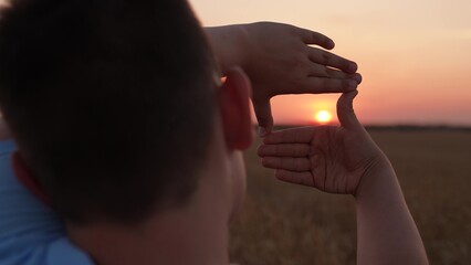 Child boy Seeing world as different Concept. Sees like in movies. Hands of teenager director cameraman making frame gesture at sunset. Business planning. Boy shows her fingers frame symbol in sun.
