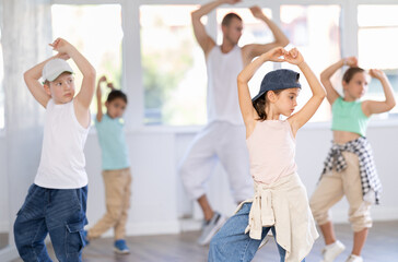 Positive girls and boys training hip hop in dance studio, dance classes for kids