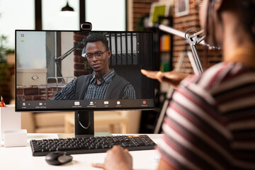 Male business advisor seen on computer screen, providing insights on strategy plans to black female...