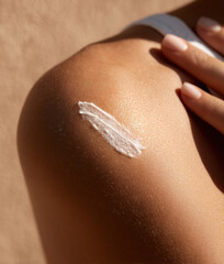 Female shoulder with moisturizing cream swatch on the skin, close-up
