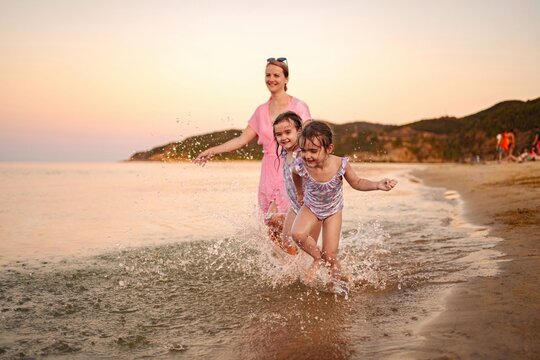 Joyful family moments splashing near the shore at sunset