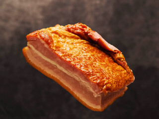 Tasty smoked pork joint in the air, dark color painted background. Fine port meat ham popular in Poland and Baltic states. Premium product, ready to eat.
