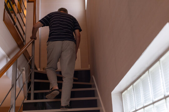 senior elderly man climbing the stairs at home, life insurance