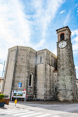 view of the historic church bell tower in Faedis, Italy, featuring a traditional clock face and...