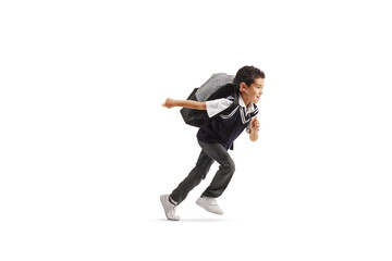 Full length profile shot of a boy in a school uniform running with a backpack