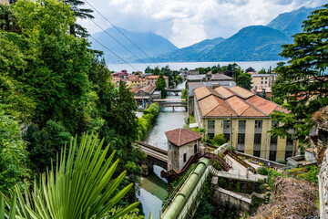 Bellano, Italy, located in the northern region of Lombardy, is shown in a wide view from Lake Como during a summer day.