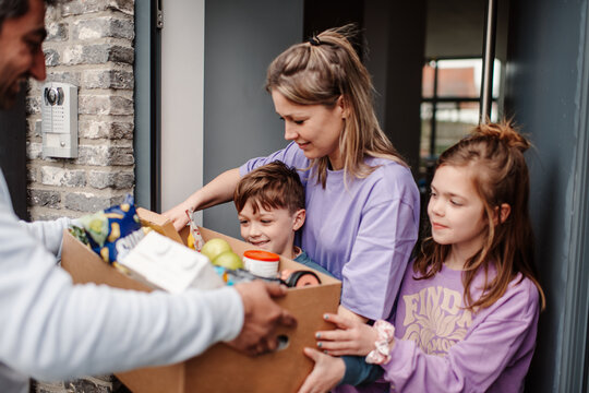 Family receiving groceries at home door