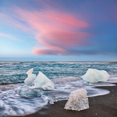 Ramarkable pieces of the iceberg sparkle on famous Diamond Beach at  Jokulsarlon lagoon during...