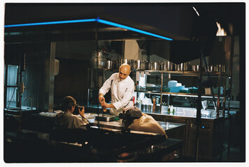 Photographers shooting professional chef at restaurant