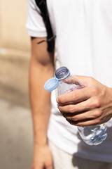 Hand holding a refreshing bottle of water on a scorching hot day in Paris. Essential hydration...