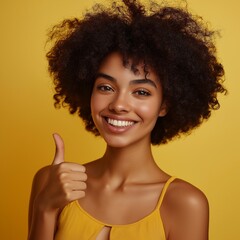 Smiling Young Adult Female with Afro Hairstyle Giving Thumbs Up on Yellow Background - Portrait of Confidence and Joyful Expression