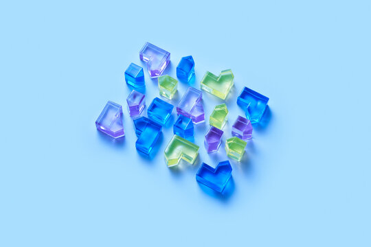 Colorful glass shapes on light blue surface
