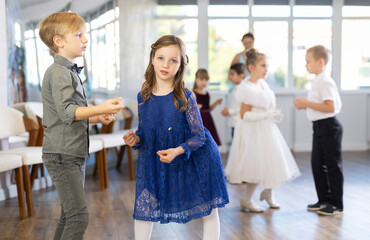 Beautifully dressed little boys and girls dance a couple twist dance