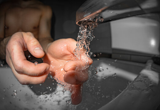 Man Washing Hands with Clean Water at Home