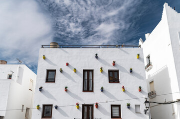 Andalusian whitewashed building with colorful decorated flower pots 