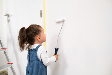 Cute girl painting the wall in a stylish living room, helping with apartment makeover.
