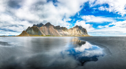 Amazing  sunny day and gorgeous reflection of Vestrahorn mountaine on Stokksnes cape in Iceland.
