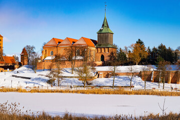 Ancient medieval village church and frozen winter river