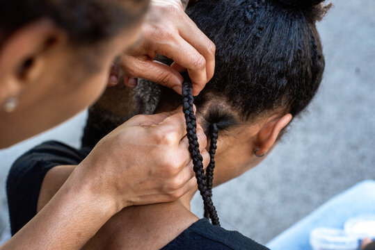 Hands braiding Hair Outdoors on a Sunny Day