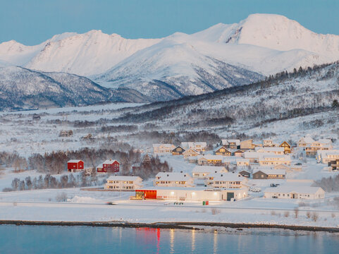 Snowy village at the foot of winter mountains