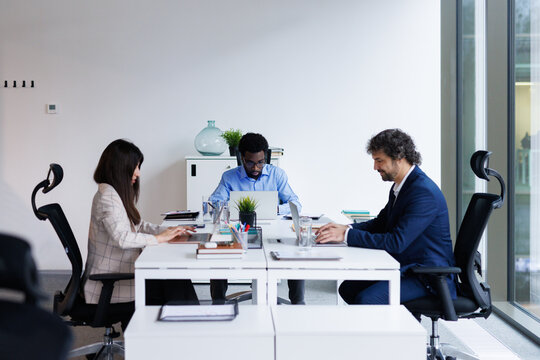 Group of IT specialists working side by side at open space office