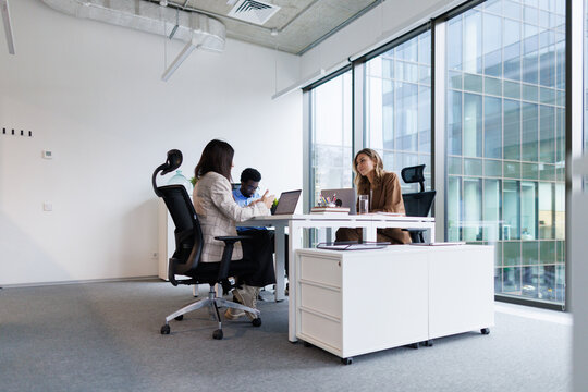 Architects brainstorming ideas sitting in office with panoramic window