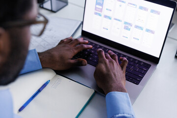 Anonymous data analyst creating chart on laptop sitting at office
