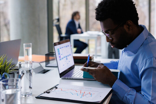 Data scientist studying information and making notes at office