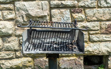 Public grill in front of rock wall