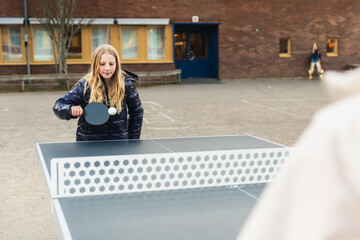 Child Playing Table Tennis Outdoors
