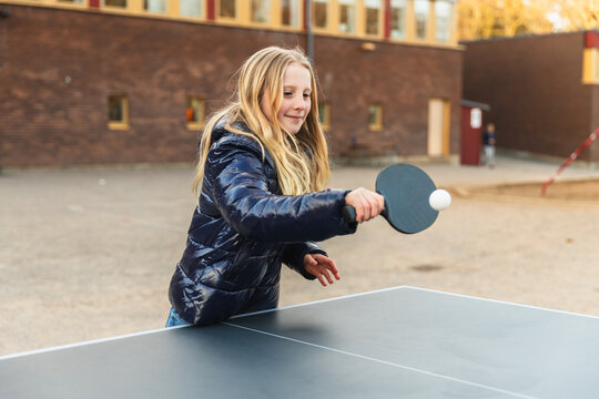 Child Playing Table Tennis Outdoors
