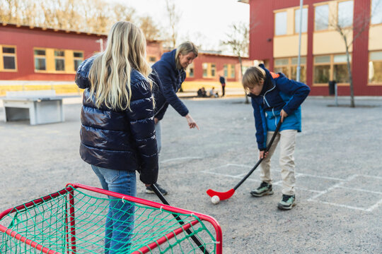 Children Playing Hockey with Adult Supervision