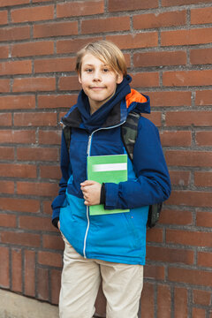 Young Student with Backpack by Brick Wal