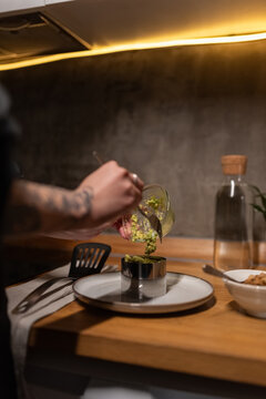 Woman adding guacamole into salad