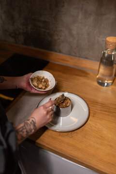 Woman adding mushrooms to salad