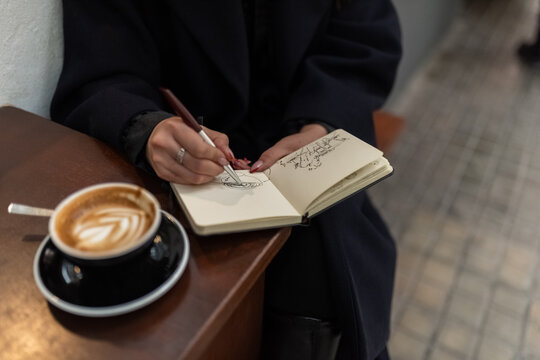 Woman drawing sketches at street cafe