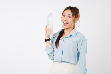 Young asian woman hold plastic water bottle, showing smile, ready to drink refreshing water for hydration, with hand on bottle of water, isolated studio white background