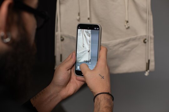 anonymous man taking pictured of details of bag