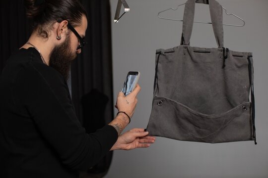 Man taking pictured of bag 