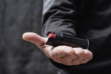 Close-up of a man hand with pepper spray canister. Concept self-defense, protection, danger prevention, and personal safety.