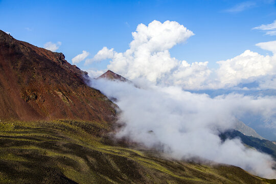 Majestic mountain view with clouds rolling through at midday